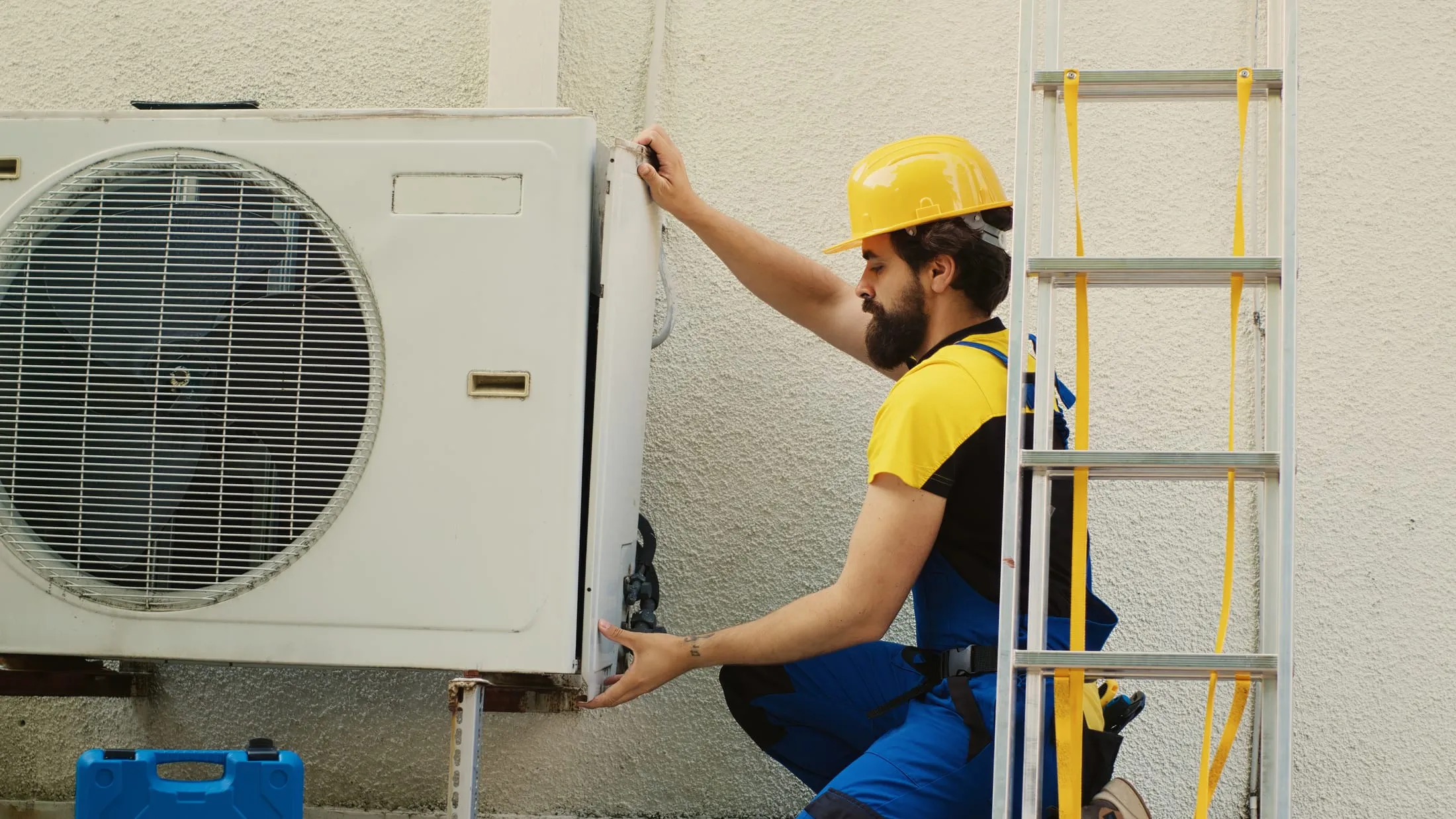 Technicien ouvrant le capot d'une unité extérieure de climatisation