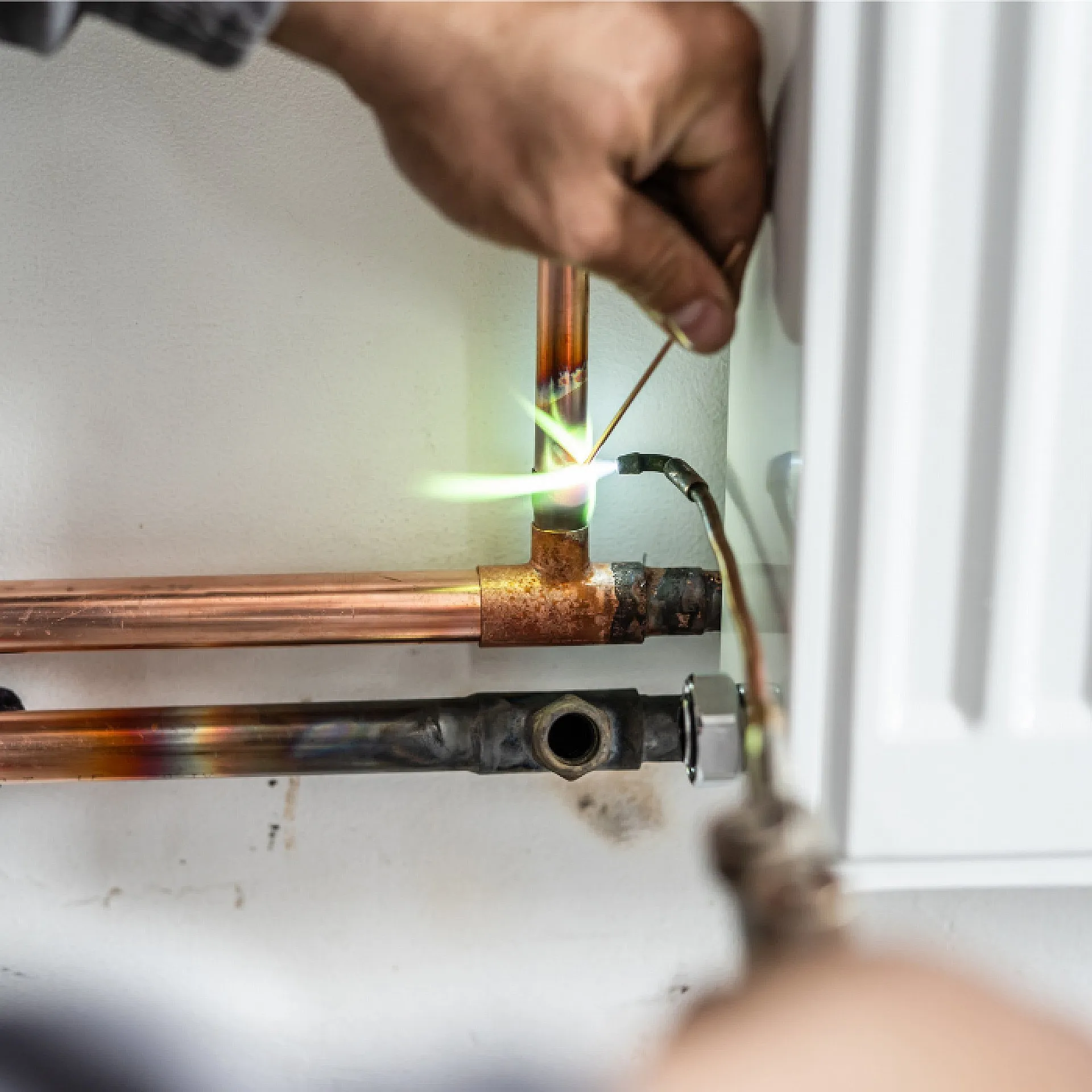 Brasure d'un raccord en cuivre sous un radiateur